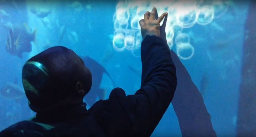 Child touches interactive wall in sensory room at Mapledown School