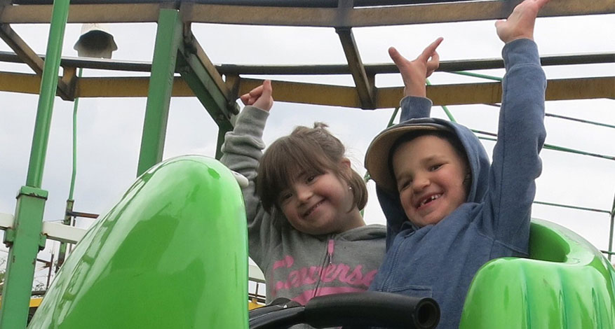 Two children who attend Kids Care playing on jungle gym.