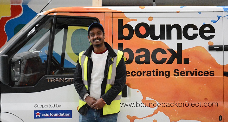 A painter and decorator stood beside branded Bounce Back van.