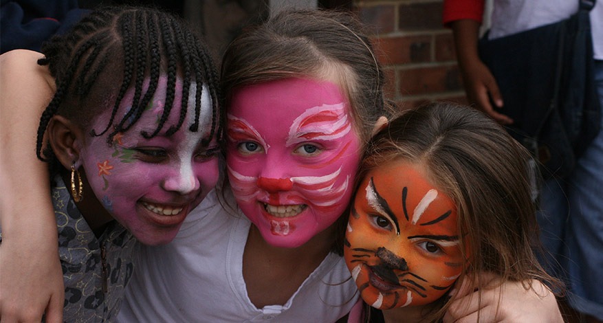 Three children have their face painted at elevating success event.
