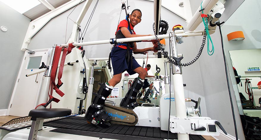 Disabled child using a gait trainer to learn how to walk at the Freddie Farmer Foundation