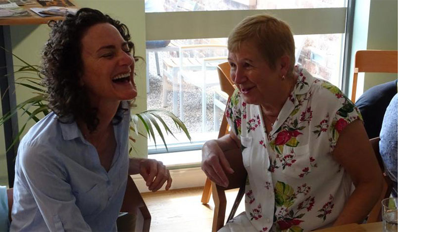 Two ladies at Omega life care laughing together.