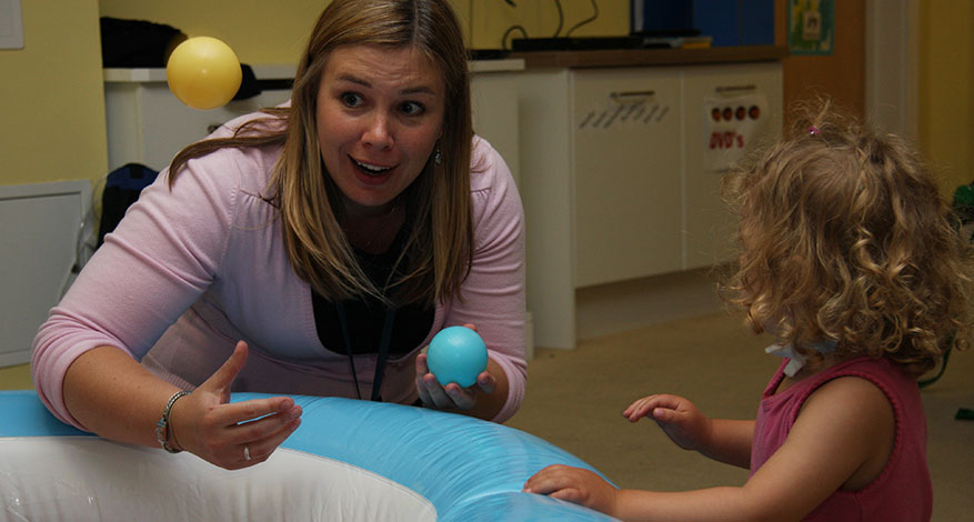 Demelza nurse plays with a child at Demelza Hospice.