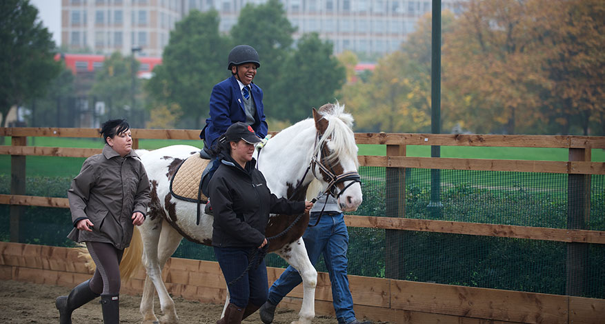 Child having a horse riding lesson at Vauxhall City farm.