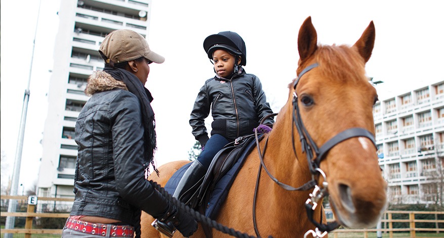 Child learning horse riding at the Ebony Horse Club