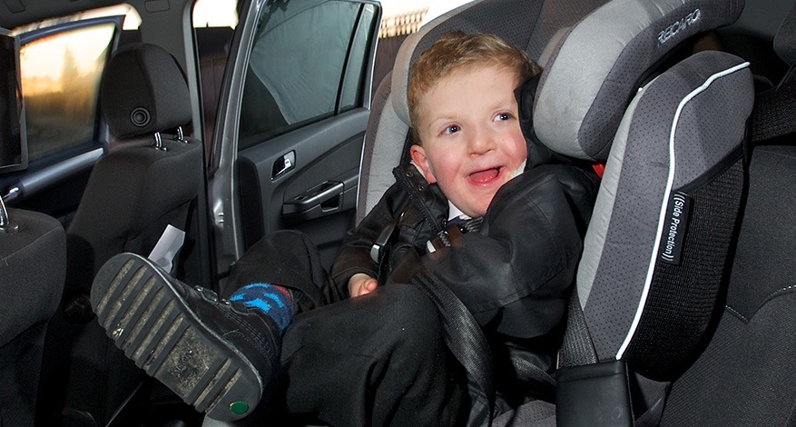 Disabled child smiling in his new specialist car seat