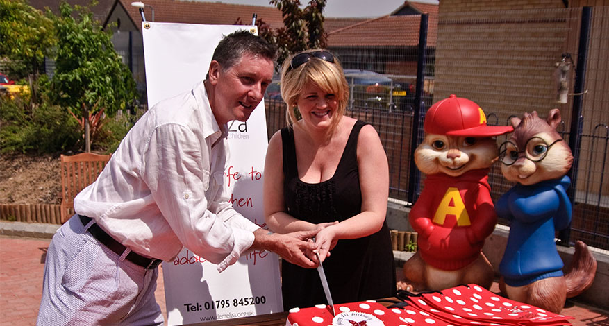 Demelza patrons cut cake at fundraising event.