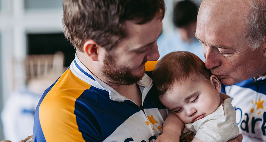 Man holding baby at Sparks Medical Research Charity