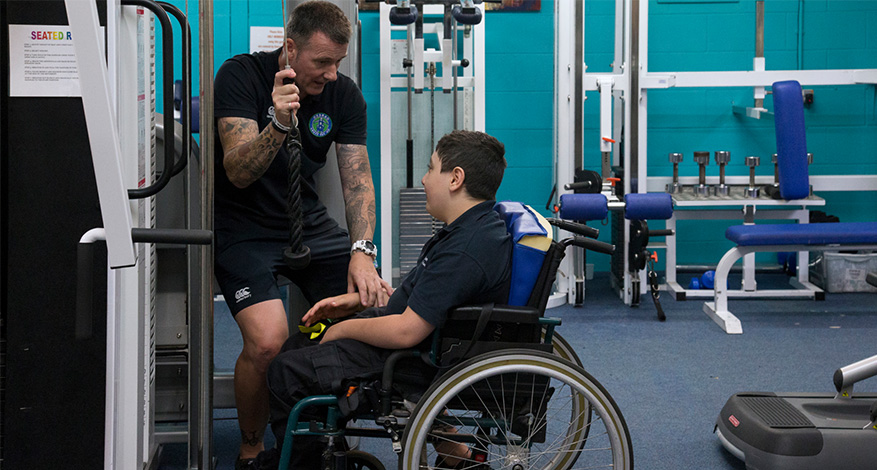 Man and boy at gym in adaptive sports centre
