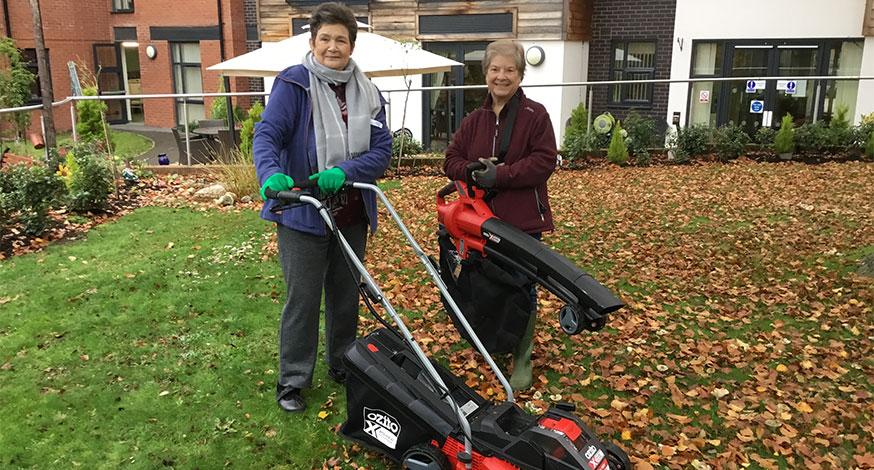 Two women at Rohan Gardens care home with gardening equipment