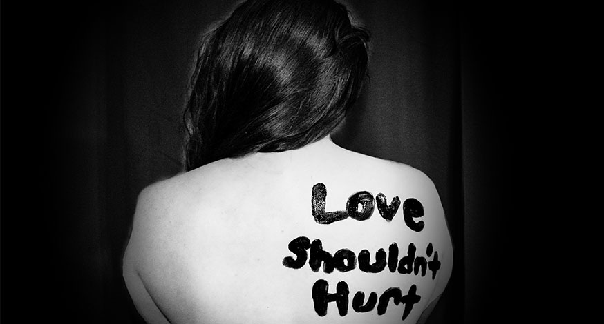 women victims of domestic abuse faces away from camera tattoo on back