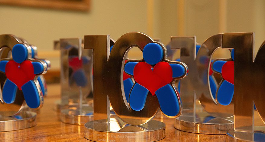 Axis Foundation Logo and Silver ten trophy on table