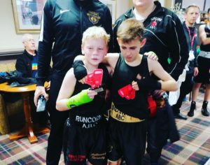 Two young boxers holding their trophies after a fight