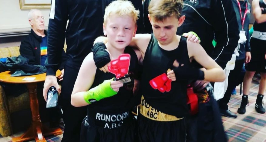 Two young boxers holding their trophies after a fight