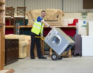 Kennet Furniture, man in high vis jacket in store room of furniture and white goods