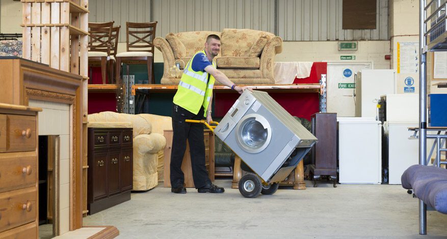 Kennet Furniture, man in high vis jacket in store room of furniture and white goods