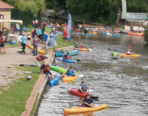 canoes and kayaks on river helping disabled young people enjoy paddlesports
