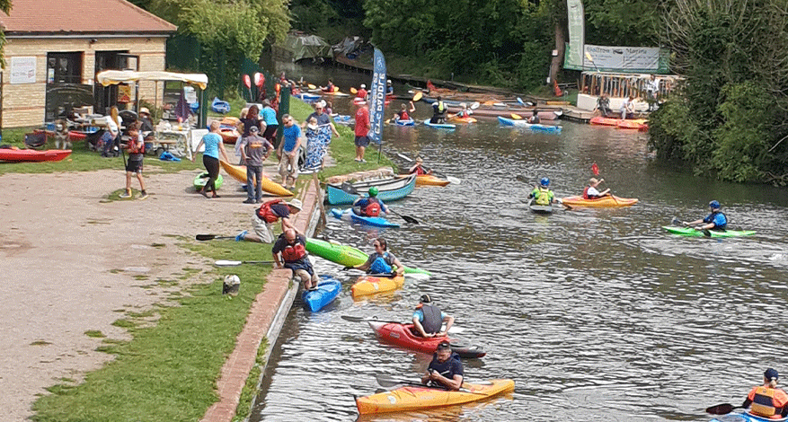 canoes and kayaks on river helping disabled young people enjoy paddlesports