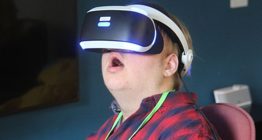 Little boy in goggles using assistive technology to communicate