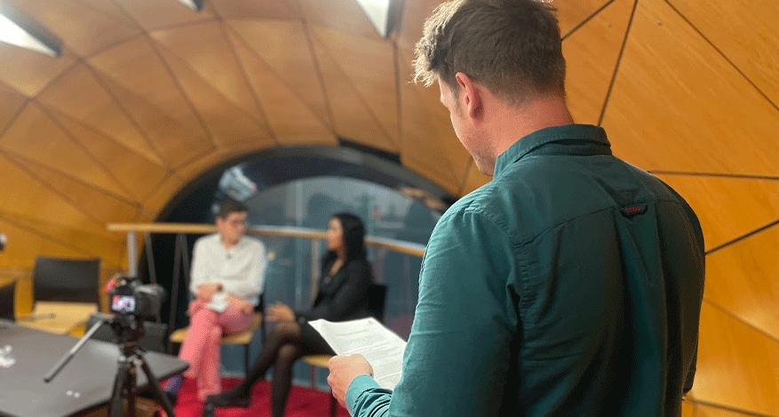 man in foreground directing two people on film set