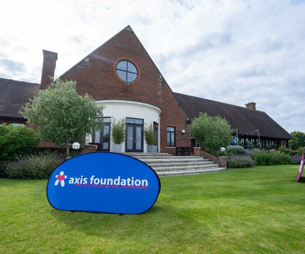 An Axis Foundation logo banner in front of the London Golf Club's clubhouse.