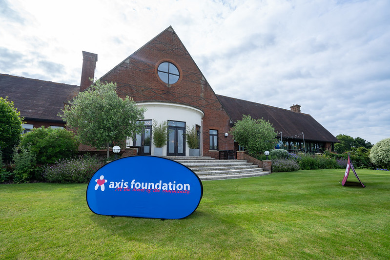 An Axis Foundation logo banner in front of the London Golf Club's clubhouse.