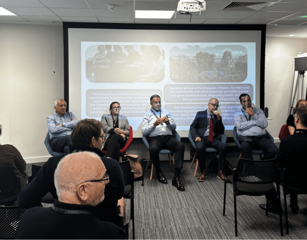 Four speakers address a room