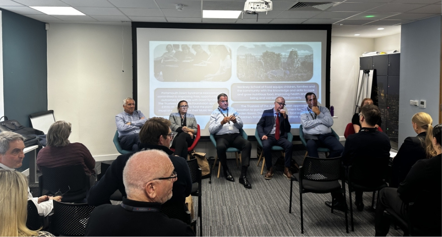 Four speakers address a room