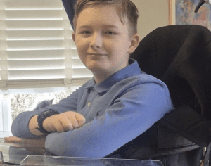 Young boy in blue shirt in wheelchair