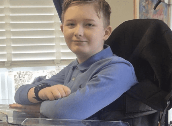 Young boy in blue shirt in wheelchair