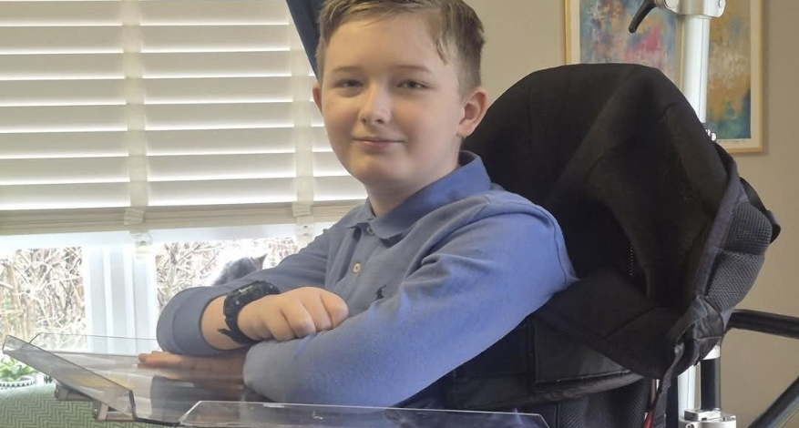 Young boy in blue shirt in wheelchair