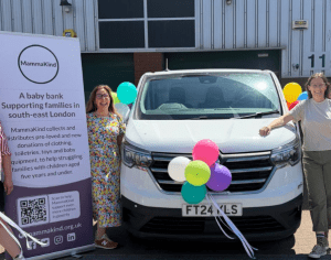 white van centre with three people and balloons plus large sign