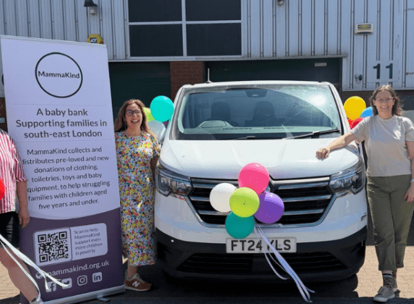 white van centre with three people and balloons plus large sign